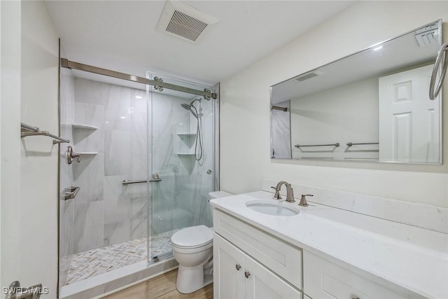 bathroom featuring tile patterned flooring, vanity, toilet, and walk in shower