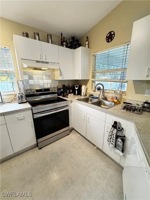 kitchen with sink, white cabinets, stainless steel range with electric cooktop, and lofted ceiling