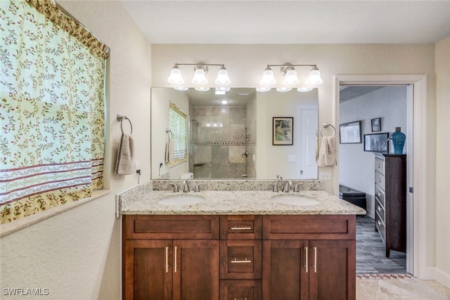 bathroom with double vanity, a stall shower, and a sink