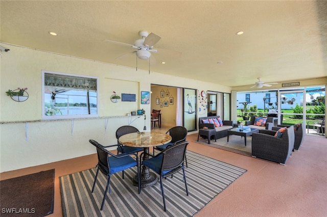 carpeted dining area featuring a ceiling fan, recessed lighting, and a sunroom