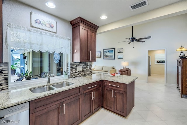 kitchen featuring visible vents, a peninsula, a sink, decorative backsplash, and stainless steel dishwasher