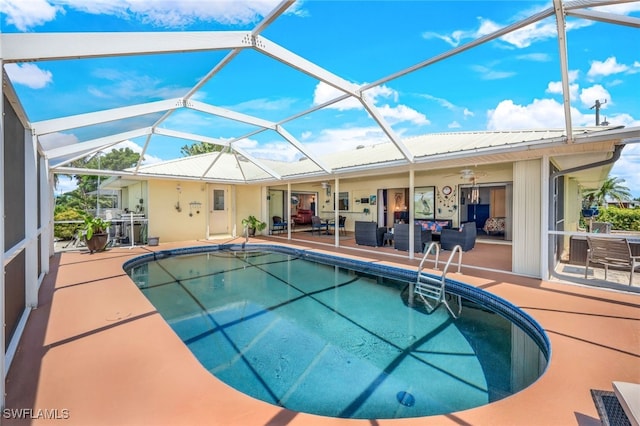 outdoor pool featuring glass enclosure, a patio, and a ceiling fan