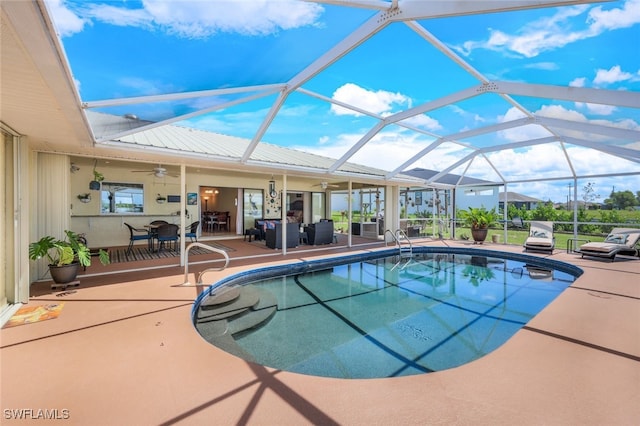 outdoor pool with glass enclosure, a ceiling fan, and a patio