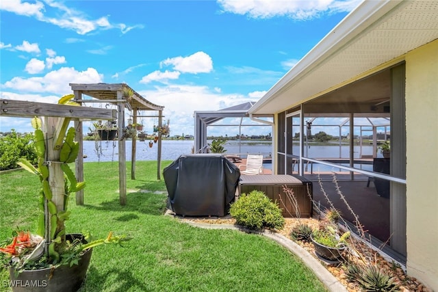 view of yard with a lanai and a water view