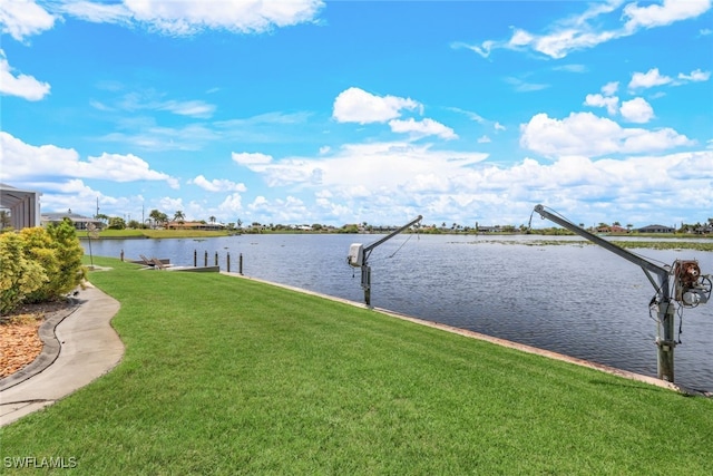 dock area with a yard and a water view