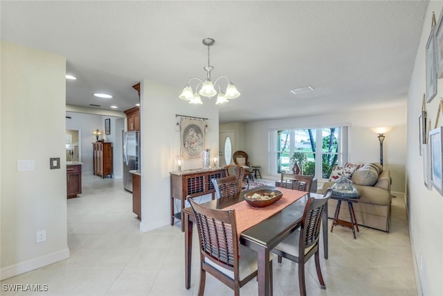 dining space with light tile patterned flooring, recessed lighting, baseboards, and an inviting chandelier