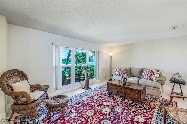 tiled living room with visible vents, baseboards, and a textured ceiling