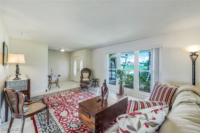 living area featuring baseboards and a textured ceiling