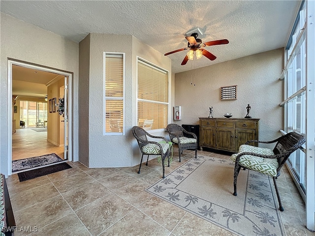 sitting room featuring ceiling fan and a textured ceiling