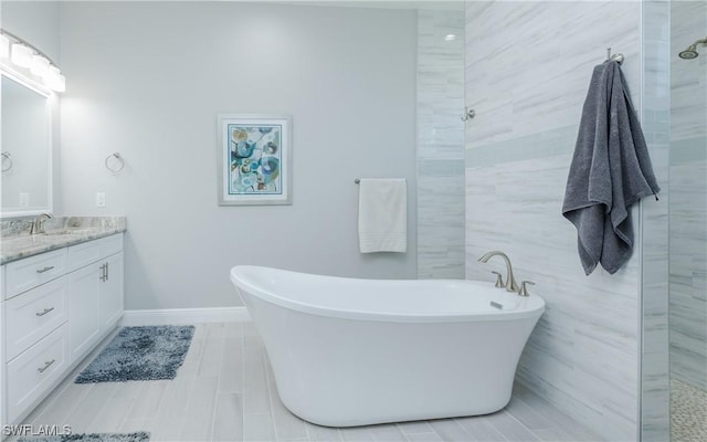 bathroom with tile patterned flooring, vanity, and a tub to relax in