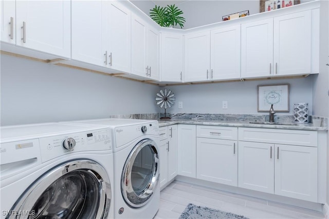 washroom featuring cabinets, washer and clothes dryer, and sink