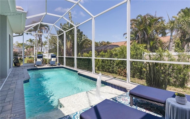 view of pool with pool water feature, a lanai, and a patio