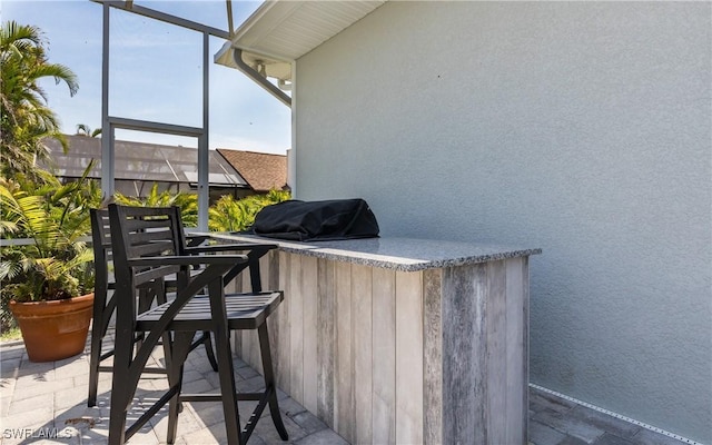 view of patio with grilling area and a bar