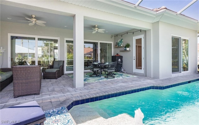 view of swimming pool with a patio, outdoor lounge area, and ceiling fan