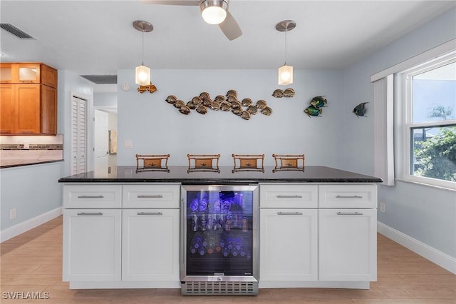 kitchen featuring white cabinets, wine cooler, and pendant lighting