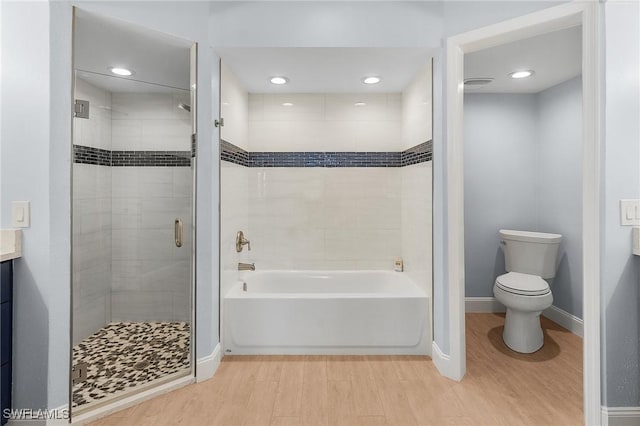 full bathroom with hardwood / wood-style flooring, toilet, shower with separate bathtub, and vanity