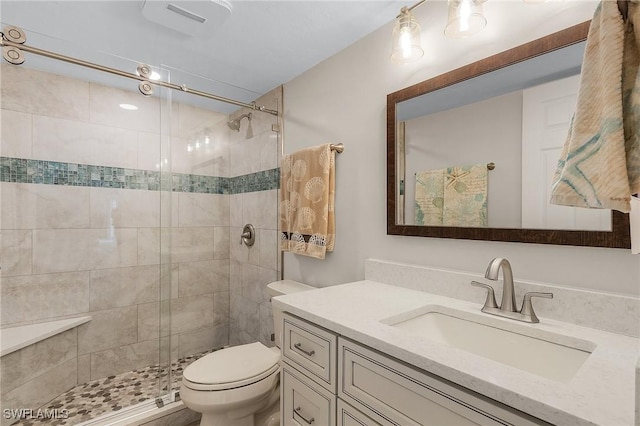 bathroom with toilet, an enclosed shower, and vanity