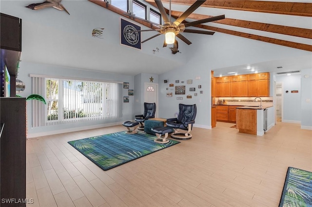 sitting room featuring ceiling fan, sink, light wood-type flooring, high vaulted ceiling, and beamed ceiling