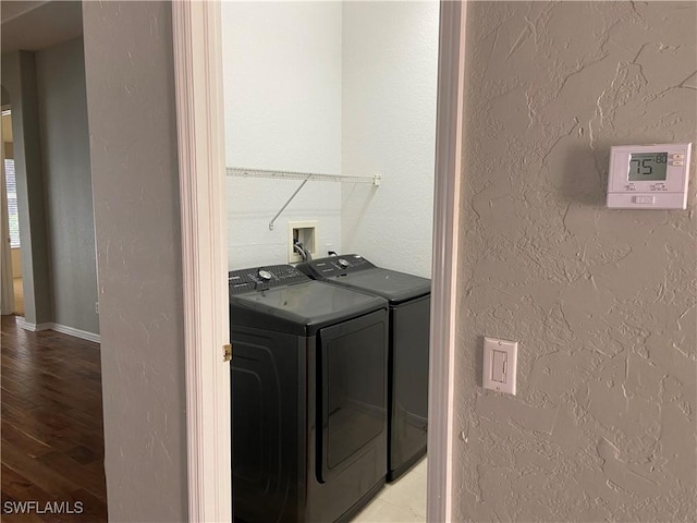 laundry area featuring separate washer and dryer and light hardwood / wood-style flooring