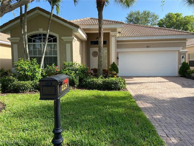 mediterranean / spanish home with a garage and a front lawn