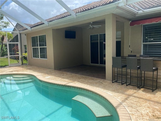 view of swimming pool with an outdoor bar, ceiling fan, and a patio area