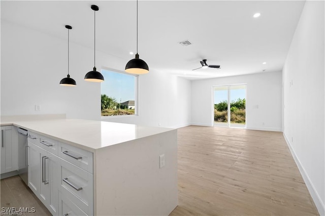 kitchen with dishwasher, decorative light fixtures, white cabinetry, kitchen peninsula, and light hardwood / wood-style flooring