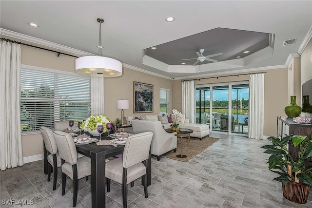 dining room with ceiling fan, a raised ceiling, and ornamental molding