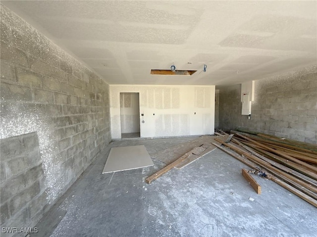 garage featuring electric panel and concrete block wall