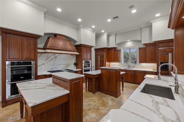 kitchen featuring a sink, crown molding, a kitchen island, double oven, and tasteful backsplash