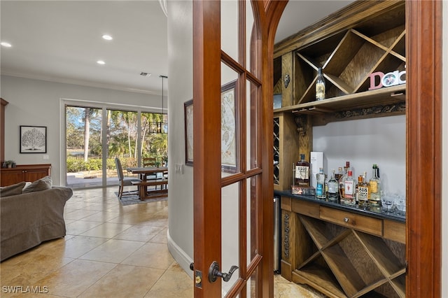 wine room featuring ornamental molding, recessed lighting, light tile patterned flooring, and a dry bar