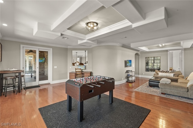 recreation room featuring french doors, ornamental molding, a raised ceiling, beam ceiling, and hardwood / wood-style floors