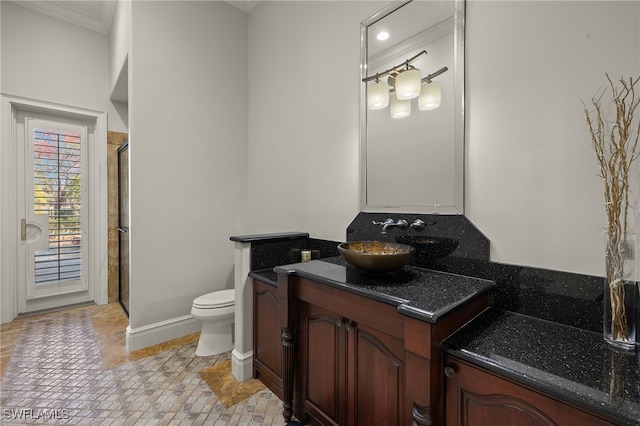 bathroom featuring crown molding, vanity, toilet, and an enclosed shower