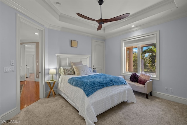 bedroom with carpet, a raised ceiling, crown molding, recessed lighting, and a ceiling fan