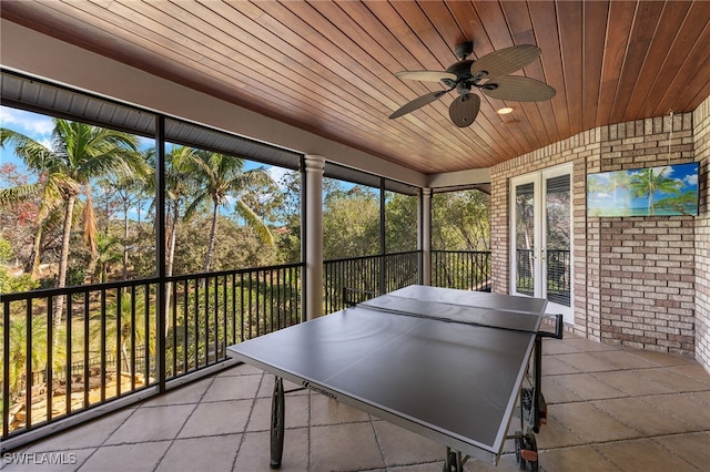 unfurnished sunroom with ceiling fan and wooden ceiling