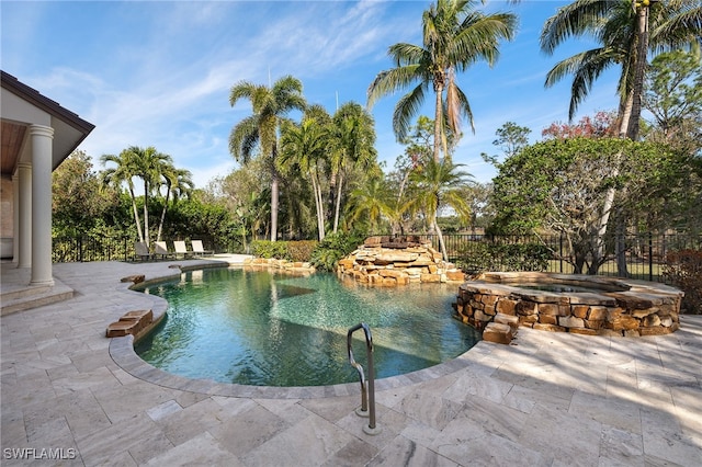 view of swimming pool with an in-ground hot tub, a patio area, and fence