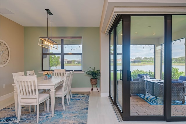 6217 Harmony Dr, Ave Maria, FL 34142 - tiled dining space featuring a water view, a notable chandelier, baseboards, and visible vents