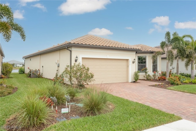 6217 Harmony Dr, Ave Maria, FL 34142 - view of home's exterior with a lawn, a garage, a tile roof, stucco siding, and decorative driveway