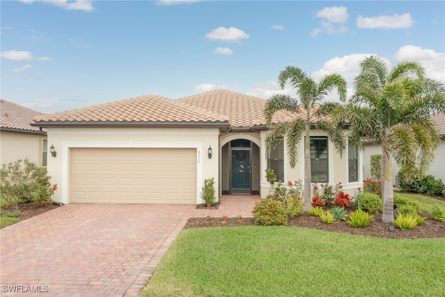 6217 Harmony Dr, Ave Maria, FL 34142 - mediterranean / spanish-style house featuring a garage, stucco siding, a tile roof, and decorative driveway