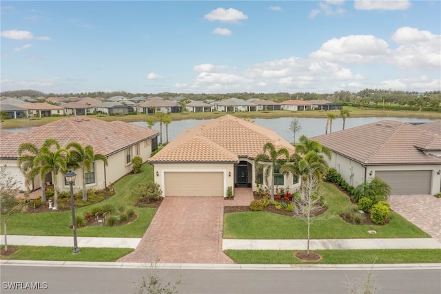 6217 Harmony Dr, Ave Maria, FL 34142 - view of front of house with a water view, a residential view, and a garage