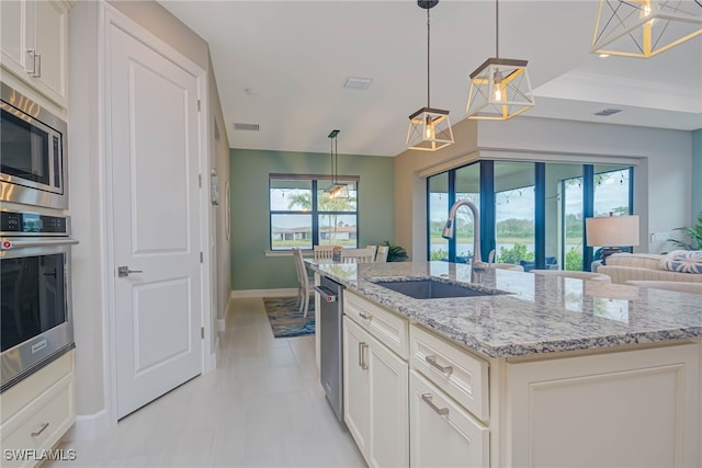 6217 Harmony Dr, Ave Maria, FL 34142 - kitchen featuring baseboards, light stone countertops, visible vents, stainless steel appliances, and a sink