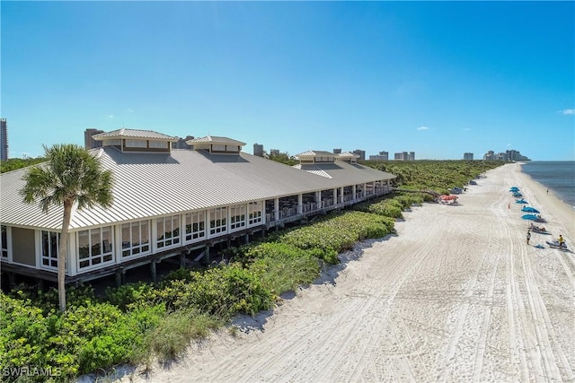 drone / aerial view with a water view and a beach view