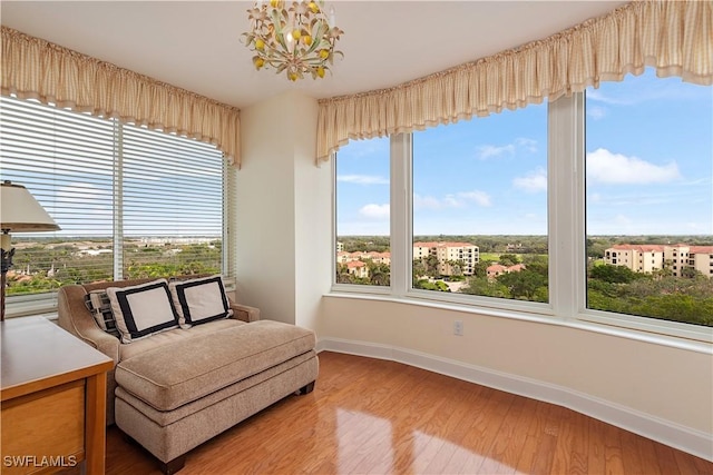 living area featuring hardwood / wood-style flooring and a notable chandelier