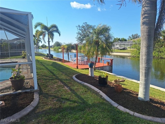 view of home's community with a water view and a lawn