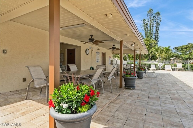 view of patio / terrace featuring fence, outdoor dining space, and a ceiling fan