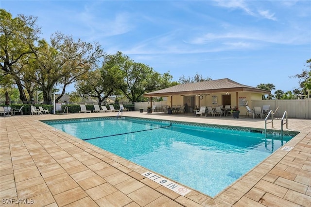 community pool featuring a patio and fence