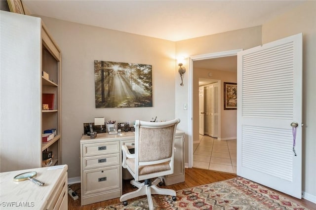 office space with baseboards and light wood-type flooring