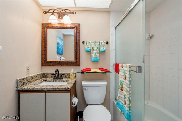 bathroom with toilet, enclosed tub / shower combo, and vanity