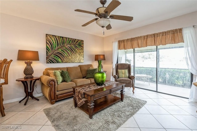 living room with light tile patterned floors, a ceiling fan, and baseboards