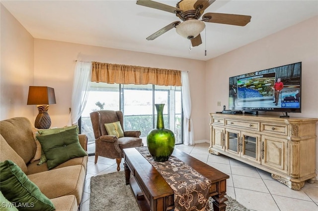 living room featuring light tile patterned floors, ceiling fan, and baseboards