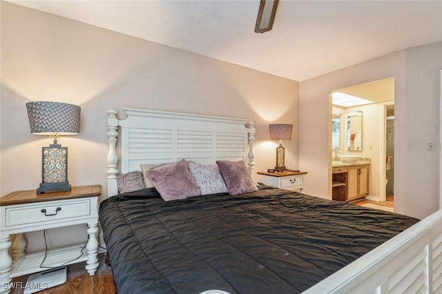 bedroom featuring wood finished floors and connected bathroom
